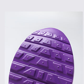 Close-up of a purple shoe sole with textured pattern on a light gray background