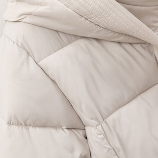 Close-up of a beige quilted jacket with a focus on texture and stitching.