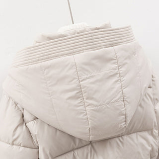 Light beige quilted jacket on a hanger against a white background