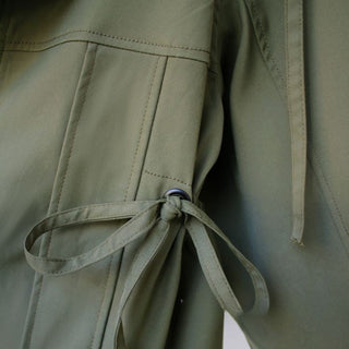 Close-up of a green jacket with a tie detail