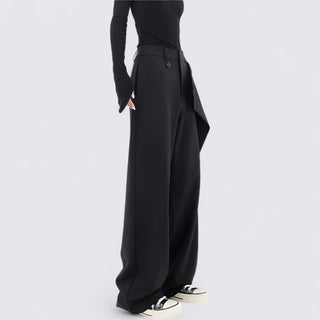 Person wearing black wide-leg pants on a light gray background