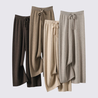 Four pairs of knit pants in different colors on a light gray background
