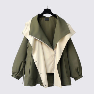 Green and beige jacket on a hanger against a light gray background