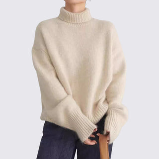 Beige sweater worn by a person on a light gray background