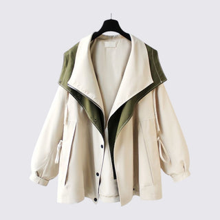 Beige jacket with green accents on a hanger against a light gray background