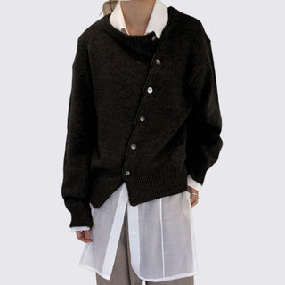 Black cardigan over a white shirt on a plain background