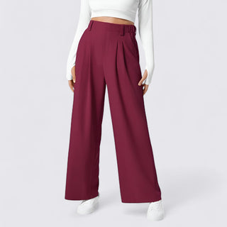 Maroon wide-leg pants worn with a white top and shoes on a light gray background