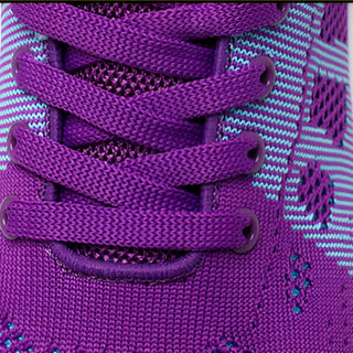 Close-up of purple shoelaces on a purple sneaker with white stripes.