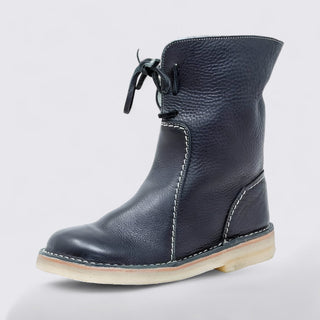 Navy blue leather boot with a white sole on a light gray background